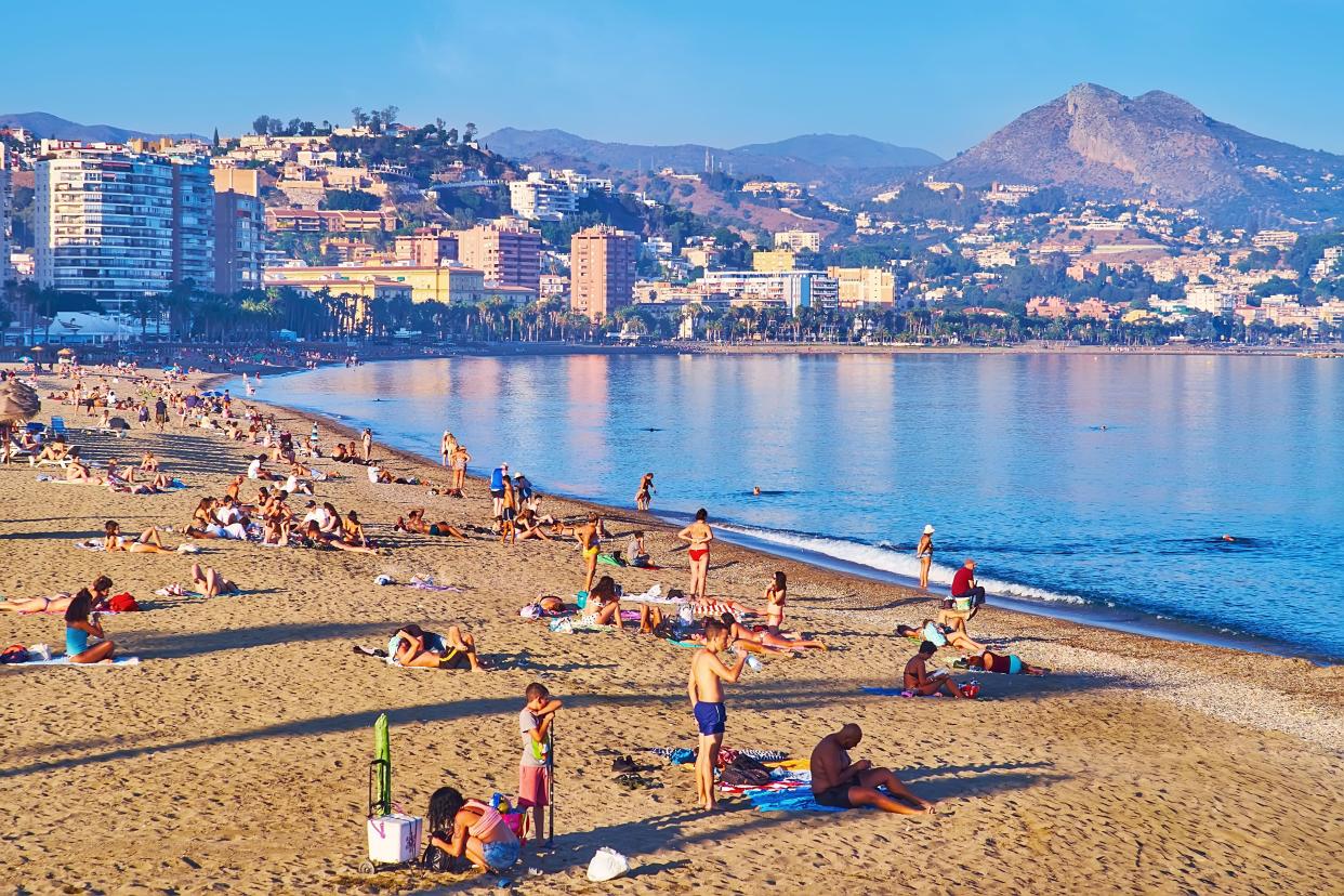 MALAGA, SPAIN - SEPT 28, 2019:  The Malagueta beach attracts tourists to relax by the sea with great mountain views, Malaga, Costa del Sol, Spain