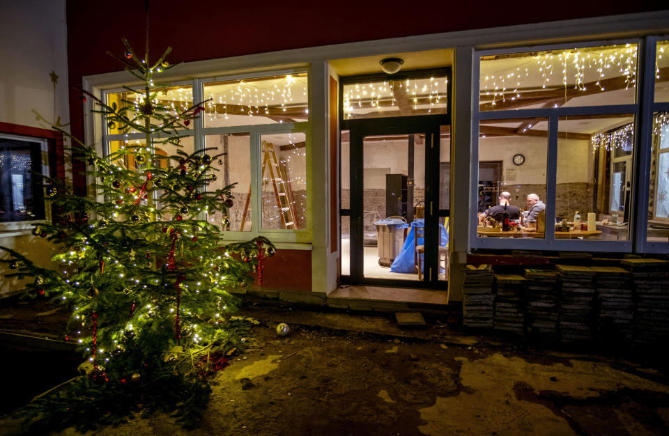 Three men take a brake from restoring the inside of a winery in Resch in the Ahrtal valley, southern Germany, Monday, Dec.13, 2021. Amid the mud and debris still clogging the streets from last summer's devastating floods, residents of the Ahr Valley in western Germany are trying to spark some festive cheer with Christmas trees. (Photo/Michael Probst)