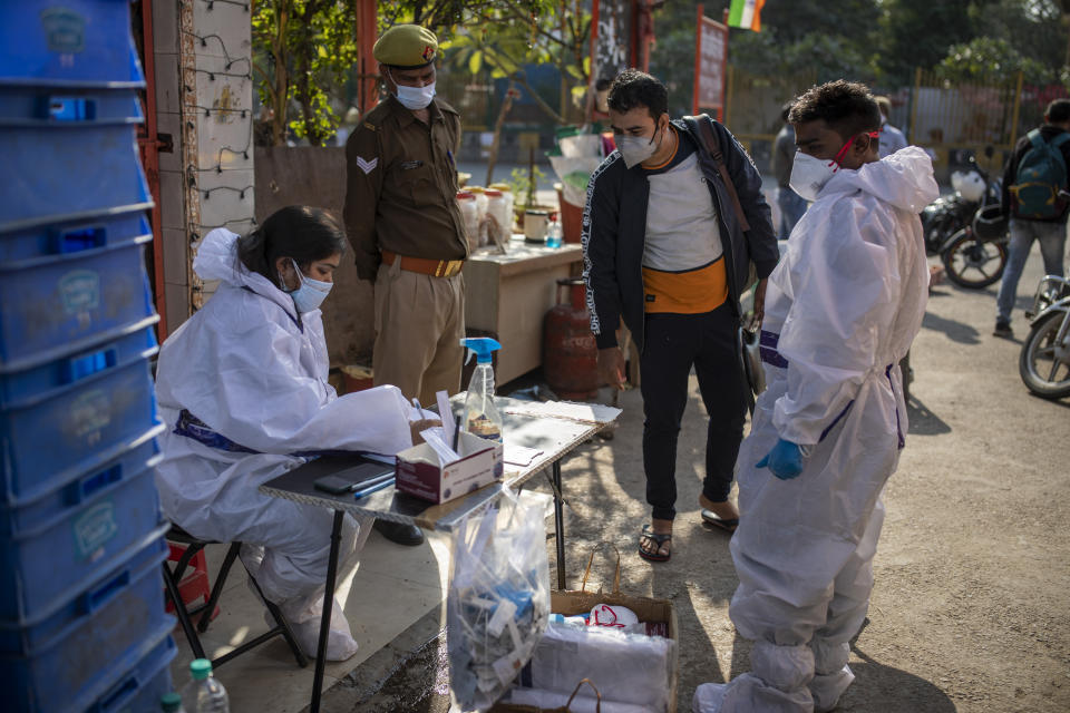 An Indian man registers his name before undergoing COVID-19 testing during during random testing of people in front of a shop at Delhi-Noida border on the outskirts of New Delhi, India, Saturday, Nov. 21, 2020. (AP Photo/Altaf Qadri)