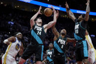 Portland Trail Blazers forward Drew Eubanks (24), guard Damian Lillard (0) and guard Gary Payton II (00) reach for a rebound in front of Golden State Warriors forward Kevon Looney during the first half of an NBA basketball game in Portland, Ore., Wednesday, Feb. 8, 2023. (AP Photo/Craig Mitchelldyer)