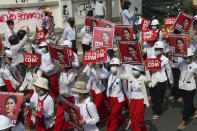 Students display images of deposed Myanmar leader Aung San Suu Kyi during a street march in Mandalay, Myanmar, Friday, Feb. 26, 2021. In the country’s second-largest city, anti-coup protesters took to the streets Friday. By midday, security forces had blocked the main road in downtown Mandalay to prevent the protesters from gathering. A writing on wall, left background, reads "No Military Dictator." (AP Photo)