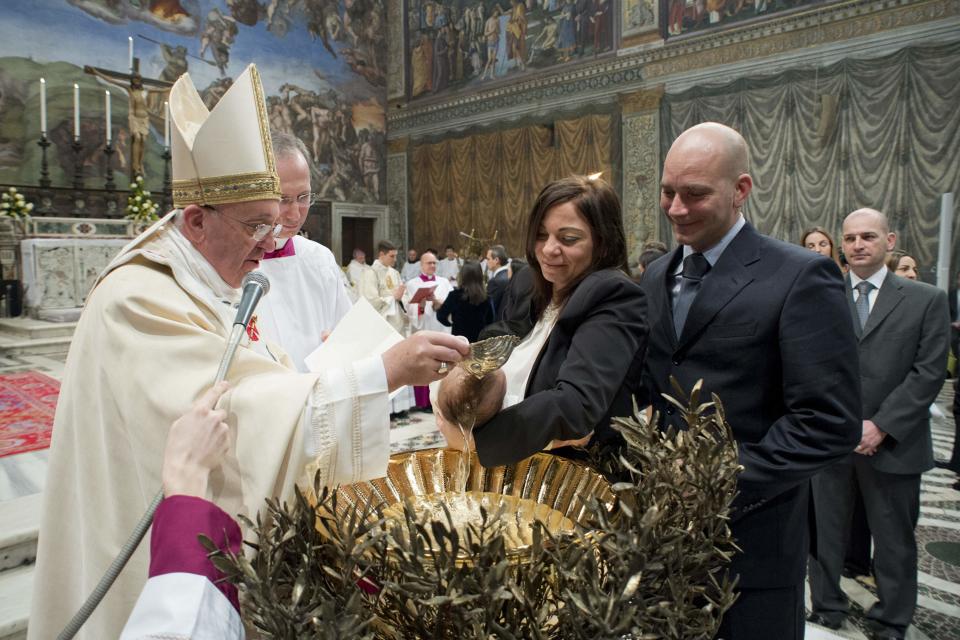 Pope Francis baptises one of 32 babies during a mass in the Sistine Chapel at the Vatican