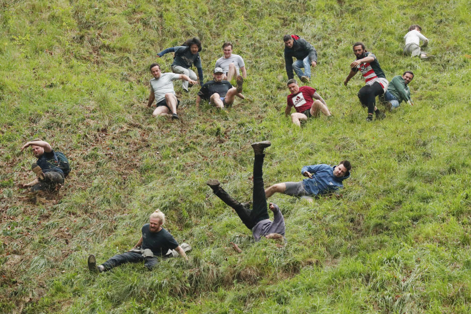 GLOUCESTER, ENGLAND - JUNE 05: Contestants in the men's downhill race chase the cheese down the hill on June 05, 2022 in Gloucester, England. The Cooper's Hill Cheese-Rolling and Wake annual event returns this year after a break during the Covid pandemic. It is held on the Spring Bank Holiday at Cooper's Hill, near Gloucester and this year it happens to coincide with the Queen's Platinum Jubilee. Participants race down the 200-yard-long hill after a 3.6kg round of Double Gloucester cheese. (Photo by Cameron Smith/Getty Images)