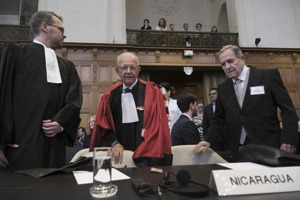 Nicaragua's Ambassador Carlos Jose Arguello Gomez, right, and Alain Pellet, center, a lawyer representing Nicaragua, arrive for the start of a two days hearing at the World Court in The Hague, Netherlands, Monday, April 8, 2024, in a case brought by Nicaragua accusing Germany of breaching the genocide convention by providing arms and support to Israel. (AP Photo/Patrick Post)