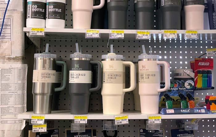 shelf full of large stanley tumblers