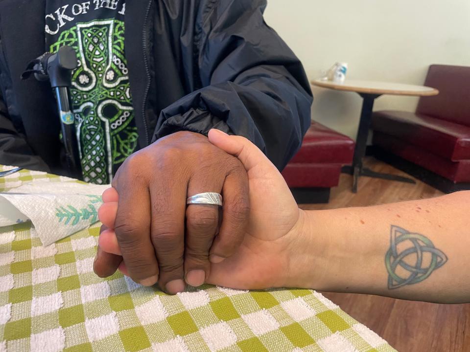 Leonard Getter, left, and Sarah Stephens hold hands after eating breakfast at Our Lady of the Road on a Friday in November. The newly engaged couple just moved into a house in the near northwest neighborhood and plan to roast their second Thanksgiving turkey this year.