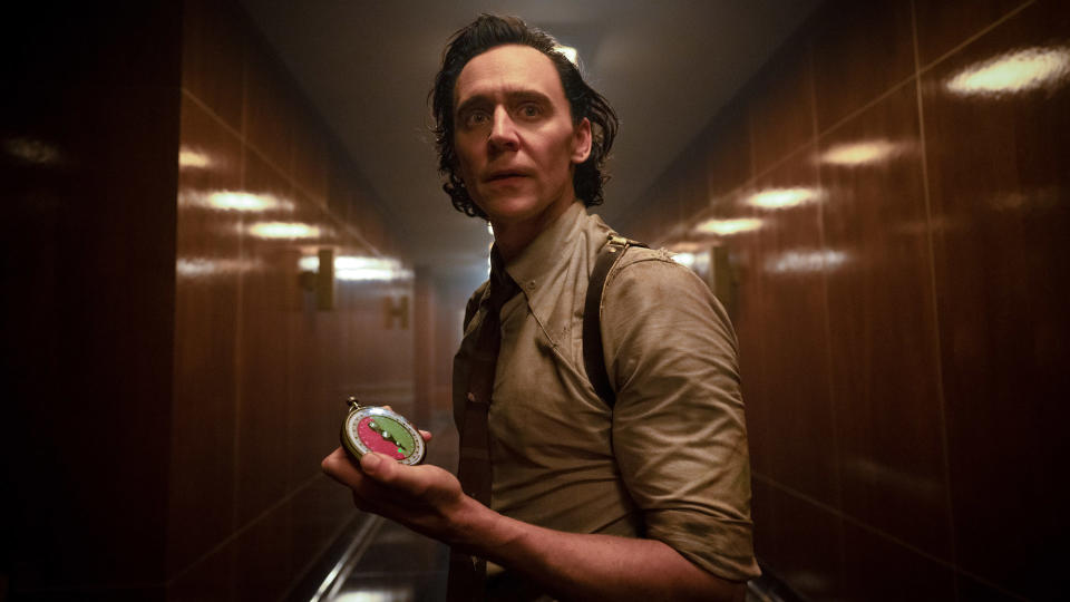 Loki looks concerned as he holds a TVA watch in Loki season 2