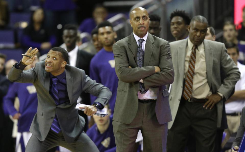 FILE - In this Jan. 18, 2017, file photo, Washington coach Lorenzo Romar, center, stands with assistant coach Michael Porter, right, as assistant coach Will Conroy signals to players during the team's NCAA college basketball game against Colorado in Seattle. Washington announced Wednesday, March 15, 2017, that Romar had been fired after 15 seasons at the school. (AP Photo/Ted S. Warren, file)