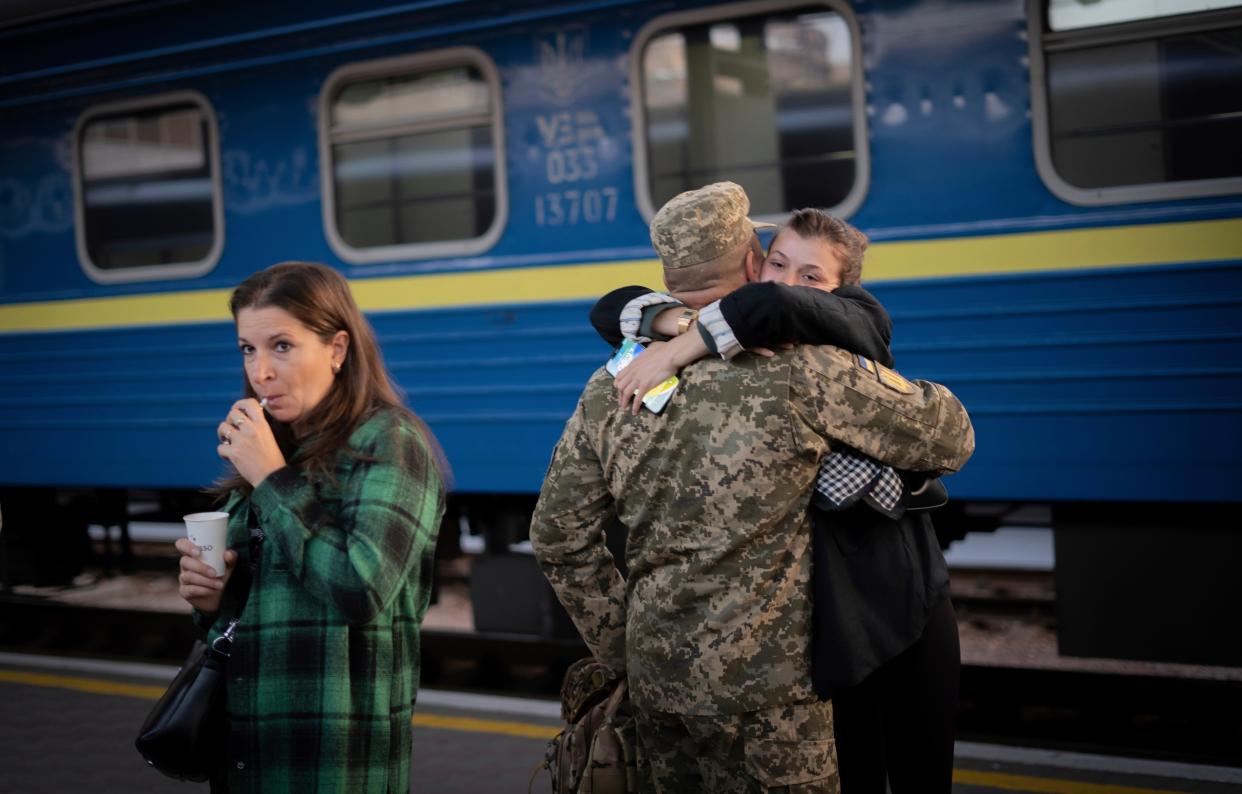 A woman hugs a Ukrainian serviceman before departure of the train to Kramatorsk (AP)
