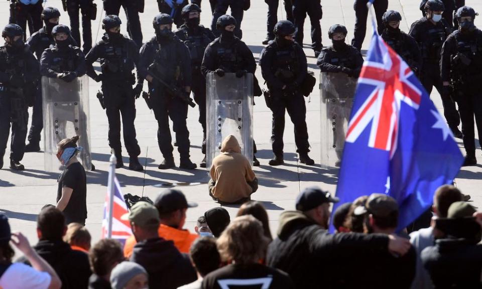 Police stand guard as demonstrators on the steps of the Shrine of Remembrance protest against Covid regulations in Melbourne