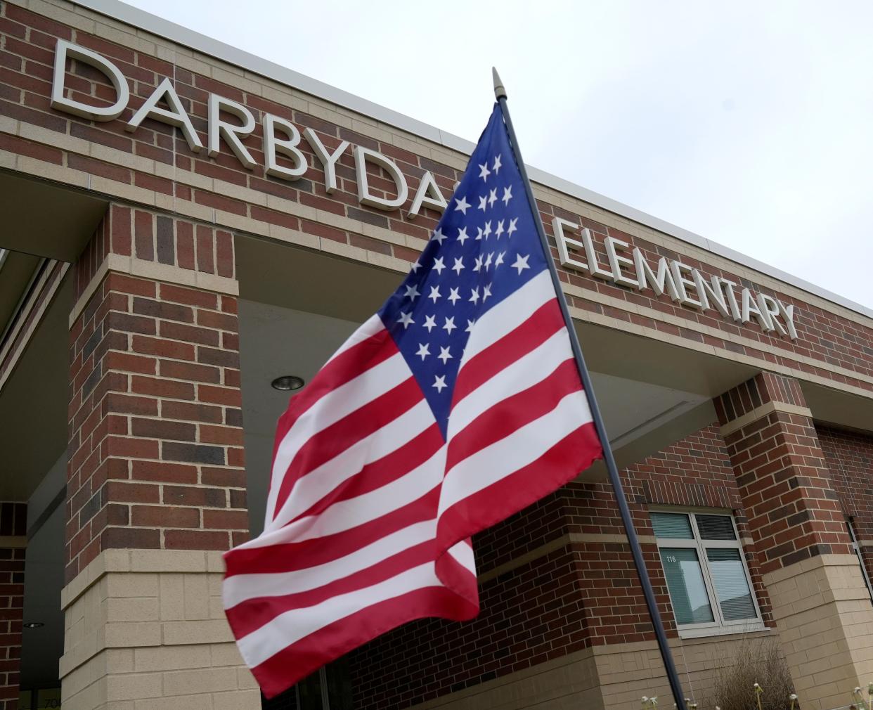 An American flag waves in the wind Tuesday outside Darbydale Elementary School in Grove City, which was the consolidated election precinct for Madison-Plains Local School District in the Franklin County portion of the school district.