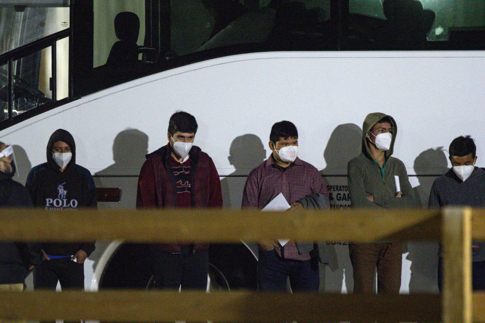 Migrant children and teenagers from the southern border of the United State wait to be processed after entering the site of a temporary holding facility Sunday, March 14, 2021 south of Midland, Texas. (Eli Hartman/Odessa American via AP)