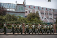 Chinese paramilitary police march in formation outside the Xinfadi wholesale food market district in Beijing, Saturday, June 13, 2020. Beijing closed the city's largest wholesale food market Saturday after the discovery of seven cases of the new coronavirus in the previous two days. (AP Photo/Mark Schiefelbein)