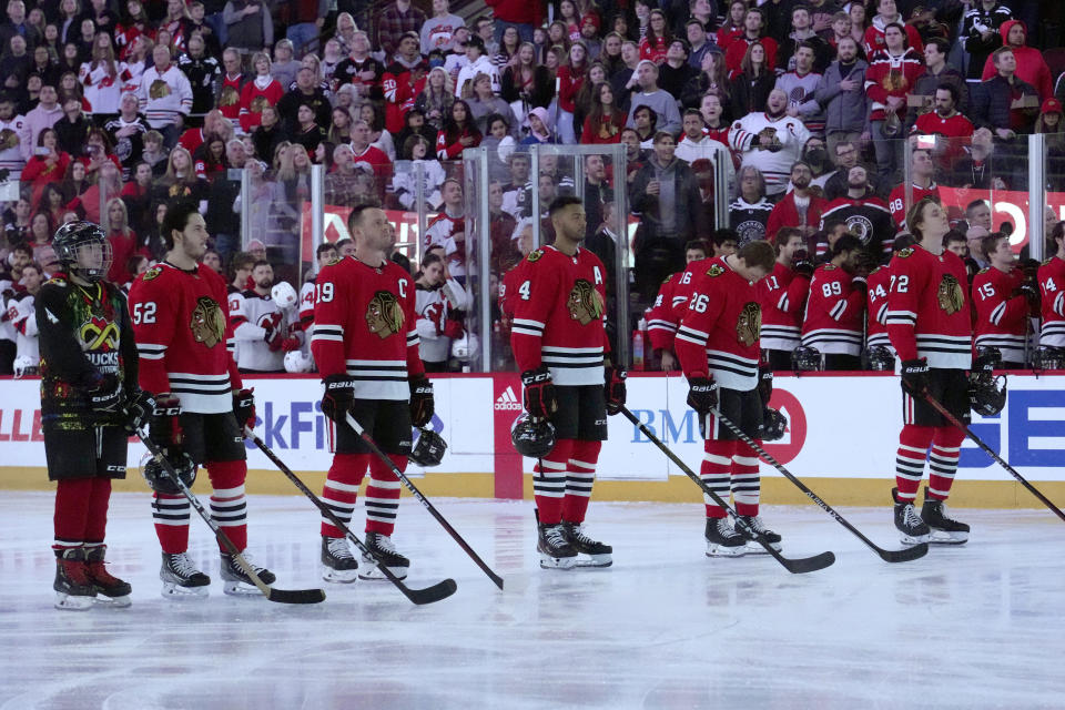 Chicago Blackhawks' Jonathan Toews (19) stands for the national anthem with Reese Johnson (52), Seth Jones (4), Austin Wagner (26) and Alex Vlasic before the team's NHL hockey game against the New Jersey Devils on Saturday, April 1, 2023, in Chicago. Toews returned from a two-month medical leave of absence. (AP Photo/Charles Rex Arbogast)