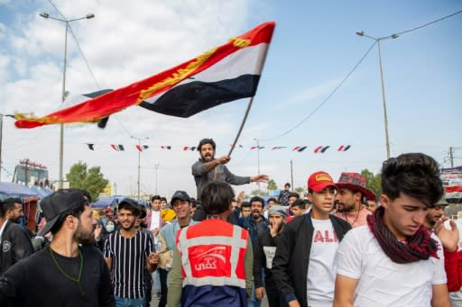 An Iraqi student waves the national flag during anti-government demonstrations in the southern city of Basra