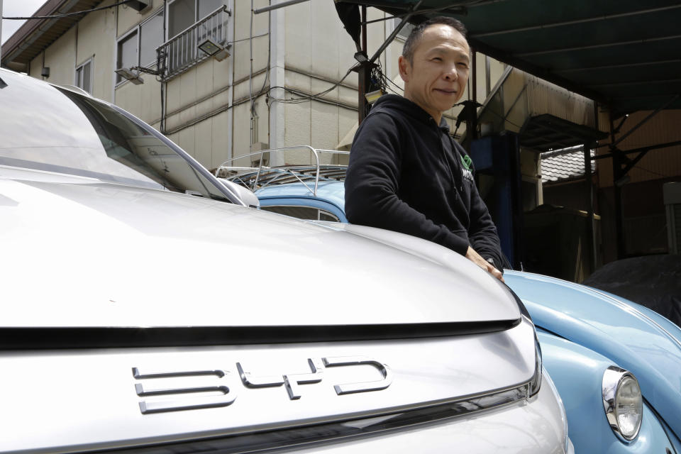 Osamu Furukawa stands next to his new BYD ATTO 3 electric car, that’s parked besides a Volkswagen converted into an EV, in Yokohama, south of Tokyo, Tuesday, April 25, 2023. BYD Auto is part of a wave of Chinese electric car exporters that are starting to compete with Western and Japanese brands in their home markets. They bring fast-developing technology and low prices that Tesla Inc.'s chief financial officer says “are scary.” (AP Photo/Yuri Kageyama)