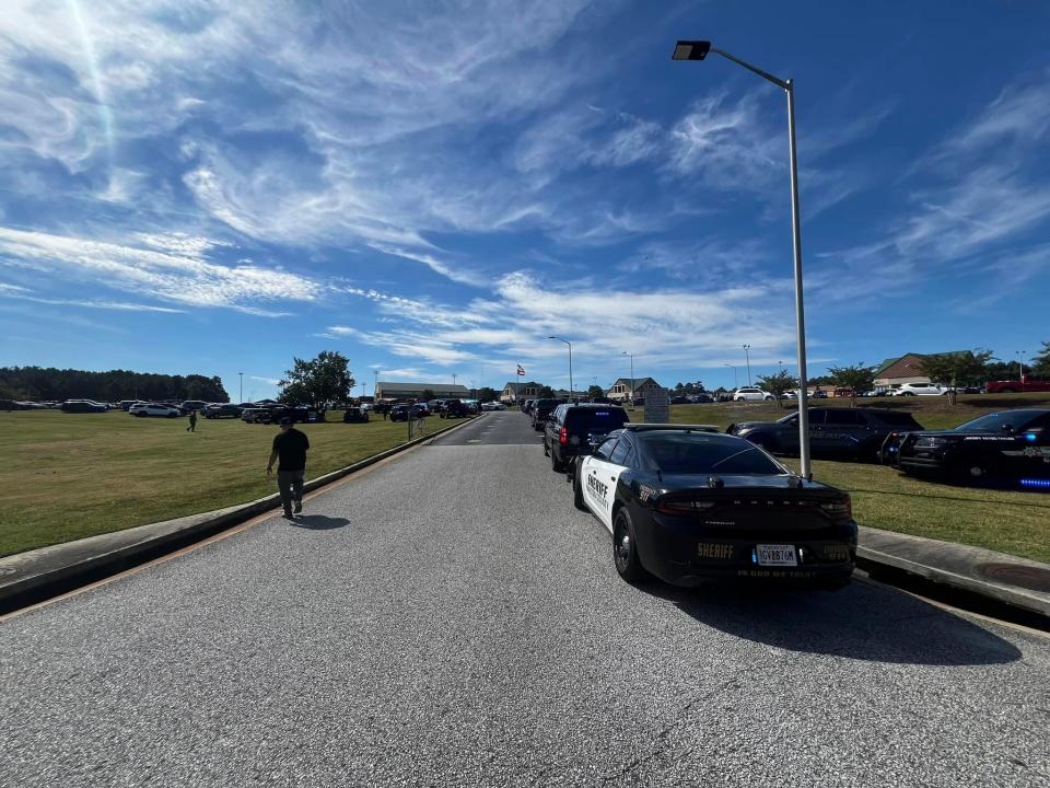 Law enforcement arrive as students are evacuated to the football stadium after the school campus was placed on lockdown at Apalachee High School in Winder, Ga., on Wednesday, Sept. 4, 2024. (Erin Clark via AP)