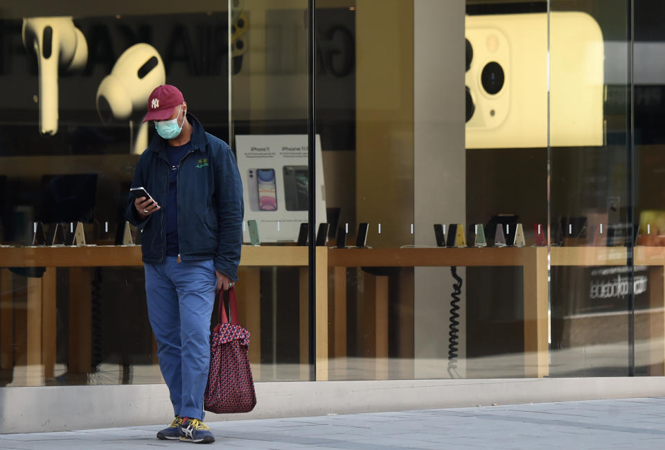 A man wearing a face mask walks past a closed electronic goods store in the center of Munich, southern Germany, on April 9, 2020 as public life in Bavaria has been limited due to the coronavirus COVID-19. (Photo by Christof STACHE / AFP) (Photo by CHRISTOF STACHE/AFP via Getty Images)