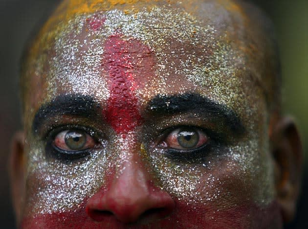 A devotee with coloured powders smeared on his face takes part in the annual Hindu religious festival of "Bonalu" in the southern Indian city of Hyderabad July 3, 2011.The word "Bonalu" is derived from the Telugu language word "Bhojanalu", the food offered to Goddess Kali, the Hindu goddess of power. The main ritual in the month-long festival consists of offering cooked rice, jaggery, curd, water and other dishes which are brought by women in earthen pots to be offered to Goddess Kali. Devotees believe that the offerings ward off evils and epidemics during the monsoon. REUTERS/Krishnendu Halder