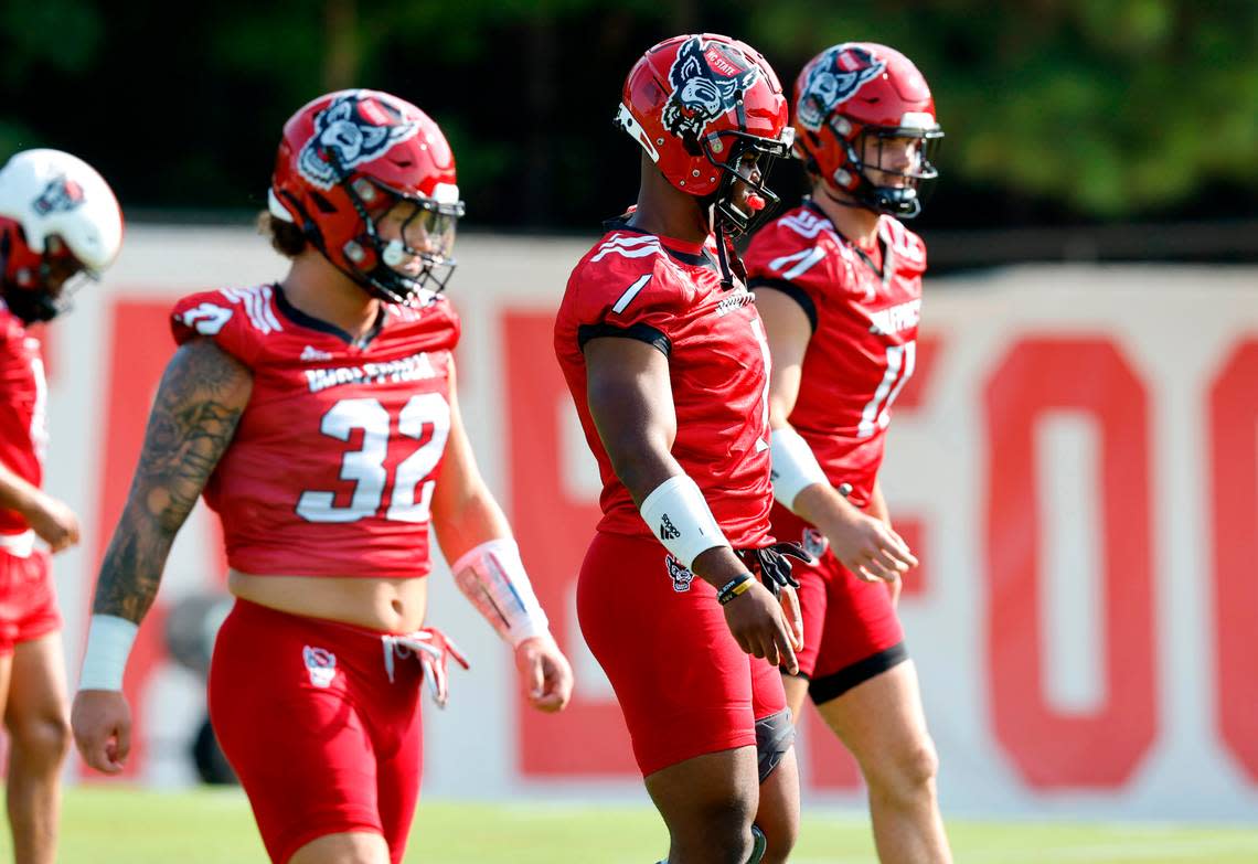 From left N.C. State linebackers Drake Thomas (32), Isaiah Moore (1) and Payton Wilson (11) line up for a drill during the Wolfpack’s first practice of fall camp in Raleigh, N.C., Wednesday, August 3, 2022.