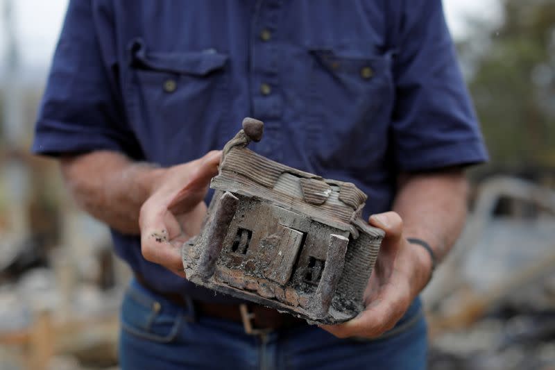 Farmer Jeff McCole, 70, displays a model house, made by his son Aaron, that remained after bushfire destroyed his family home in Buchan, Victoria, Australia