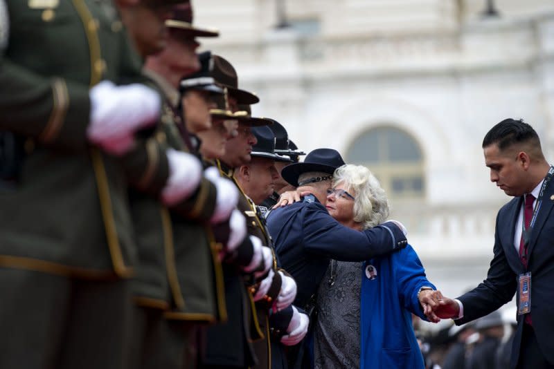 Connie Moyer (C), National President of the National Concerns of Police Survivors, hugs a member of law enforcement on Wednesday during the National Peace Officers' Memorial Service. Photo by Bonnie Cash/UPI