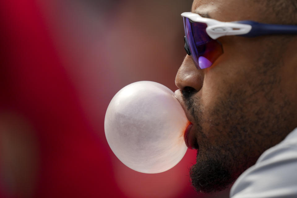 Washington Nationals' Nasim Nunez blows a bubble with his gum while sitting in the dugout during a baseball game against the Cincinnati Reds in Cincinnati, Sunday, March 31, 2024. (AP Photo/Aaron Doster)