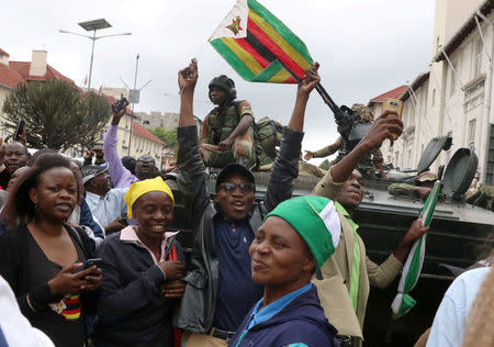 Protesters calling for Zimbabwean President Robert Mugabe to step down cheer in front of a military vehicle in Harare, Zimbabwe, November 18, 2017. REUTERS/Philimon Bulawayo