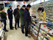 People line up to buy face masks at a pharmacy in Shanghai, Monday, Jan. 27, 2020. China on Monday expanded sweeping efforts to contain a viral disease by extending the Lunar New Year holiday to keep the public at home and avoid spreading infection as the death toll rose to 80. (Chinatopix via AP)