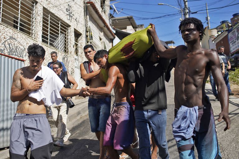 Residentes de la favela Complexo do Alemao llevan el cadáver de un hombre muerto durante una redada policial en Río de Janeiro, Brasil, el 21 de julio de 2022.