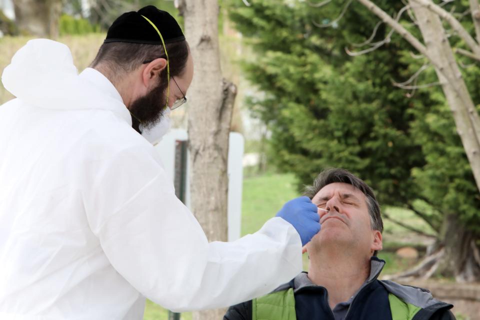 Paramedic David Rosenberg tests Elliot Cohen to confirm he is negative for COVID-19 on March 31. Members of the Young Israel of New Rochelle synagogue, who are symptom-free after testing positive for the coronavirus, began donating blood to see whether they have enough antibodies to fight off COVID-19. Cohen says he feels well and is happy to help find treatments for people in need.