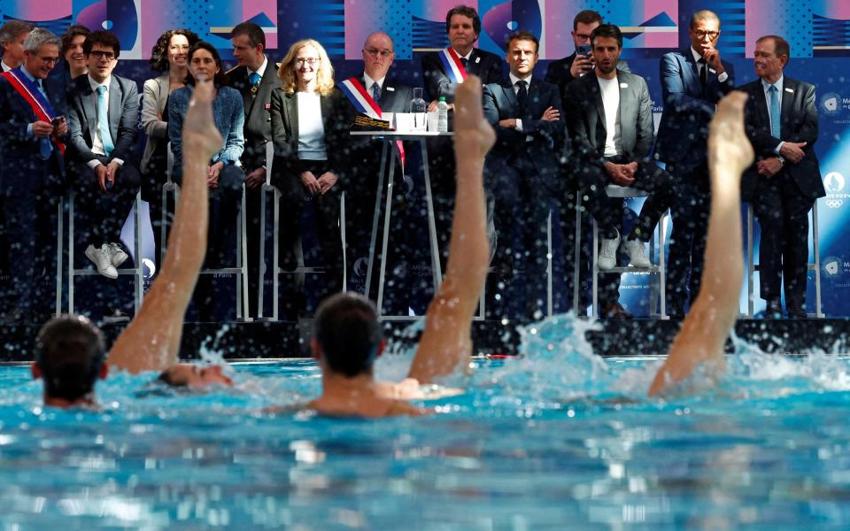 Officials including French President Emmanuel Macron watch synchronised swimming during an event to inaugurate the Olympics aquatic centre near Paris