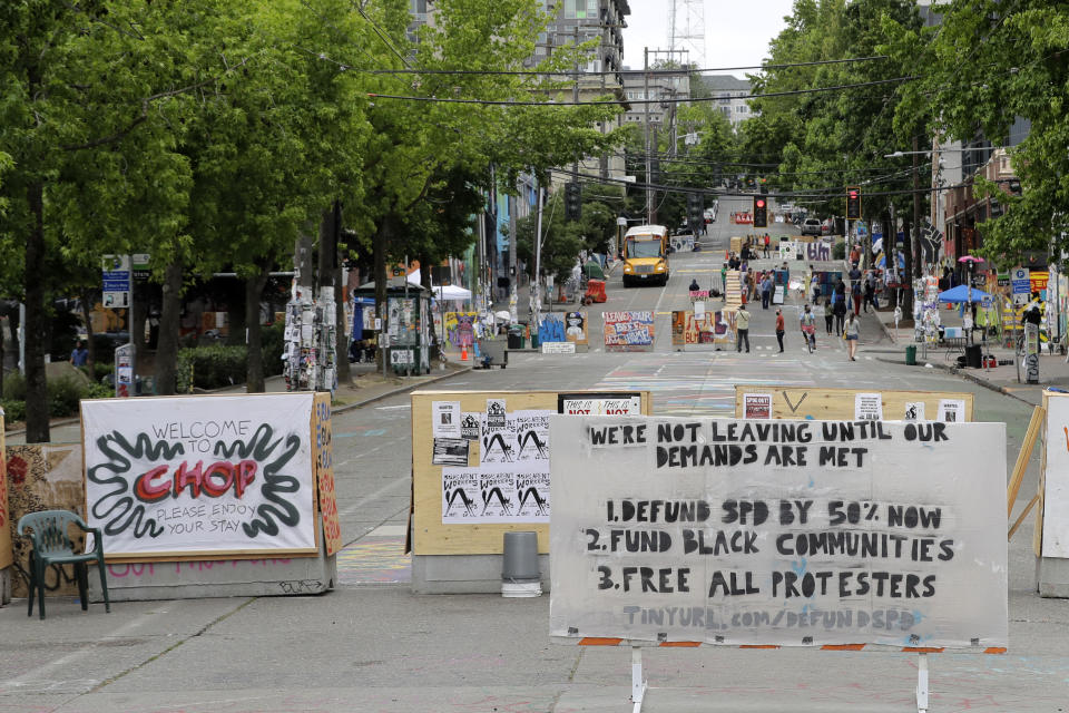 A sign on the street welcomes visitors and a list of demands is posted Wednesday, June 24, 2020, inside the CHOP (Capitol Hill Occupied Protest) zone in Seattle. The area has been occupied since a police station was largely abandoned after clashes with protesters, but Seattle Mayor Jenny Durkan said Monday that the city would move to wind down the protest zone following several nearby shootings and other incidents that have distracted from changes sought peaceful protesters opposing racial inequity and police brutality. (AP Photo/Ted S. Warren)