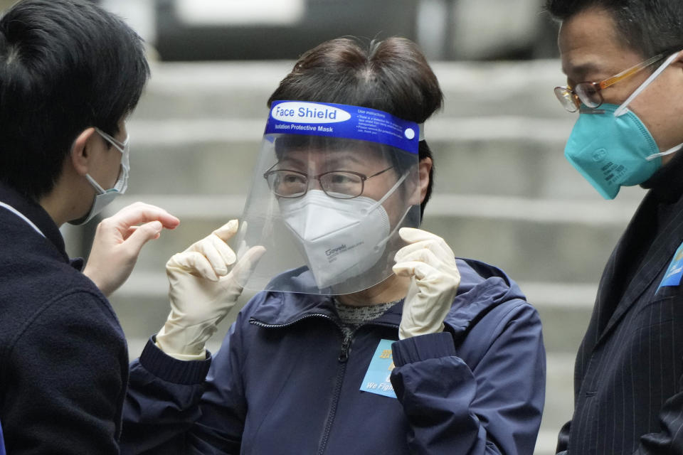 Hong Kong Chief Executive Carrie Lam, center, wears a face shield before delivering package of coronavirus prevention materials to people during an anti-epidemic event in Hong Kong, Saturday, April 2, 2022. Hong Kong authorities on Saturday asked the entire population of more than 7.4 million people to voluntarily test themselves for COVID-19 at home for three days in a row starting next week. (AP Photo/Kin Cheung)