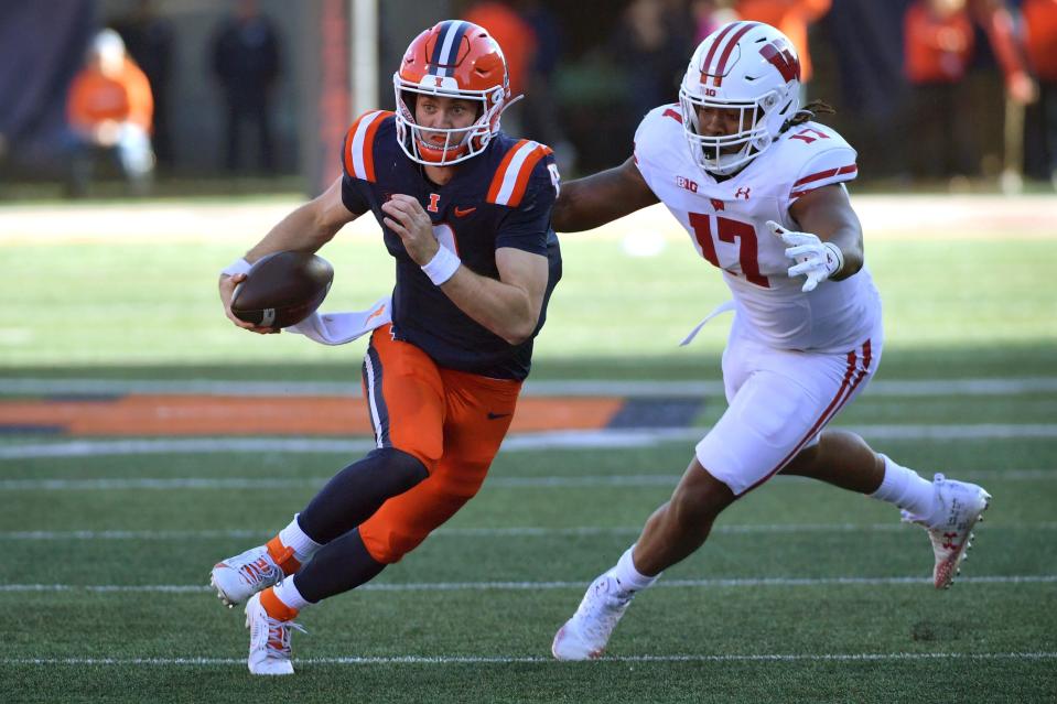 Oct 21, 2023; Champaign, Illinois, USA; Illinois Fighting Illini quarterback Luke Altmyer (9) runs the ball against Wisconsin Badgers linebacker Darryl Peterson (17) during the first half at Memorial Stadium. Mandatory Credit: Ron Johnson-USA TODAY Sports