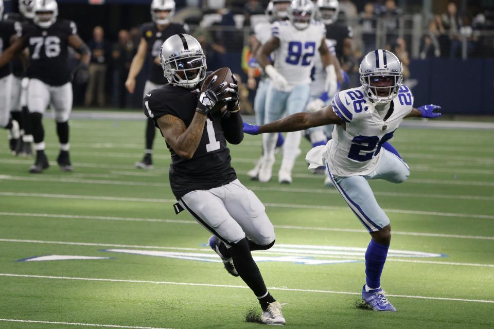 Las Vegas Raiders wide receiver DeSean Jackson (1) catches a pass for a touchdown as Dallas Cowboys cornerback Jourdan Lewis (26) defends in the first half of an NFL football game in Arlington, Texas, Thursday, Nov. 25, 2021. (AP Photo/Michael Ainsworth)