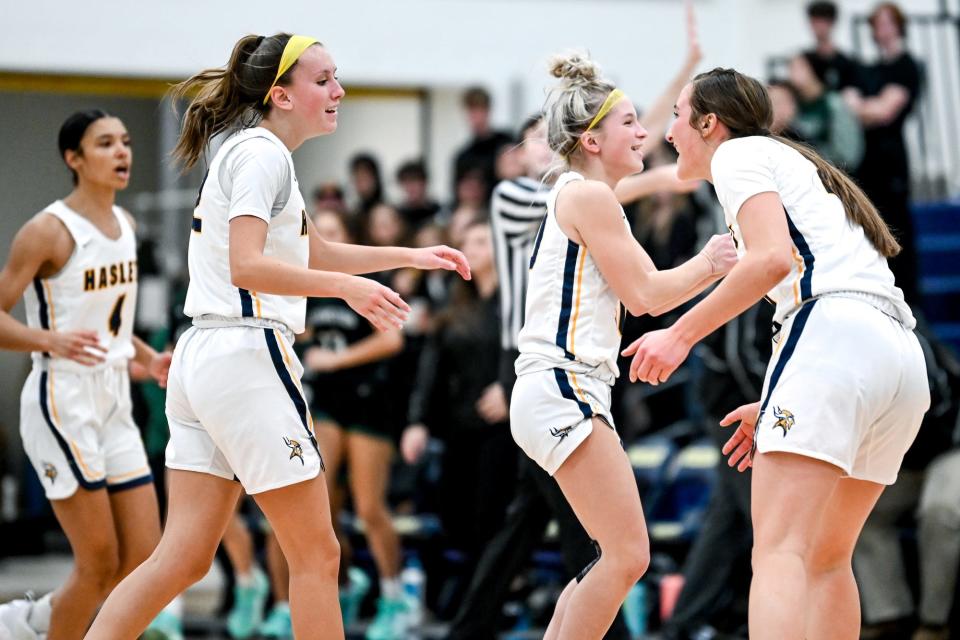 From left, Haslett's Isabel Lindo, Alexis Turner and Emily Homan celebrate after a Williamston timeout during the third quarter on Friday, Dec. 16, 2022, at Haslett High School.