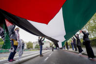 People hold a Palestinian flag as they march in solidarity with the Palestinian people amid the ongoing conflict with Israel, during a demonstration in London, Saturday, May 15, 2021. (AP Photo/Alberto Pezzali)