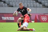 <p>Canada's Connor Braid (L) is tackled by Britain's Dan Bibby (R) in the men's pool B rugby sevens match between Britain and Canada during the Tokyo 2020 Olympic Games at the Tokyo Stadium in Tokyo on July 26, 2021. (Photo by Ben STANSALL / AFP)</p> 