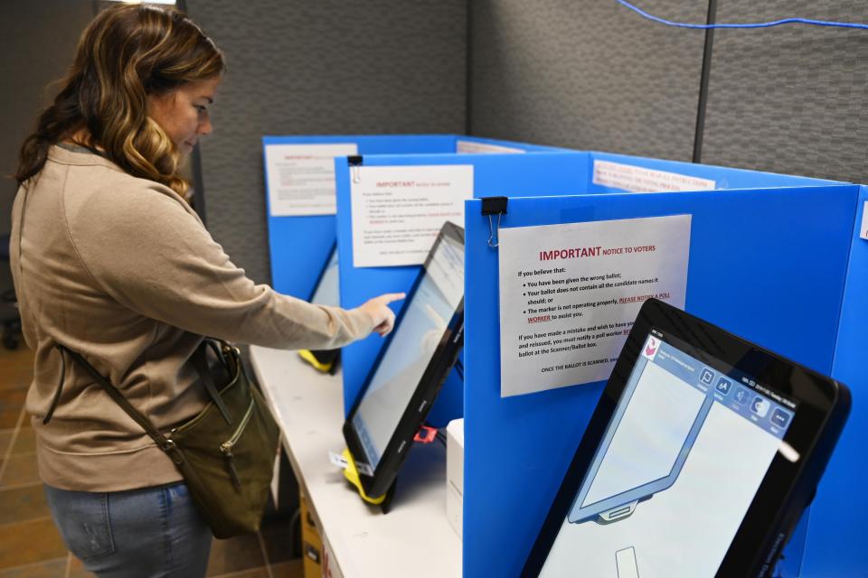 FILE-In this Tuesday, Nov. 5, 2019 file photo, Courtney Parker votes on a new voting machine, in Dallas, Ga. Voting integrity advocates will try this week to convince a federal judge that the state of Georgia should scrap its touchscreen voting machines in favor of hand-marked paper ballots, while the state will ask her not to order any changes, especially so close to an election.