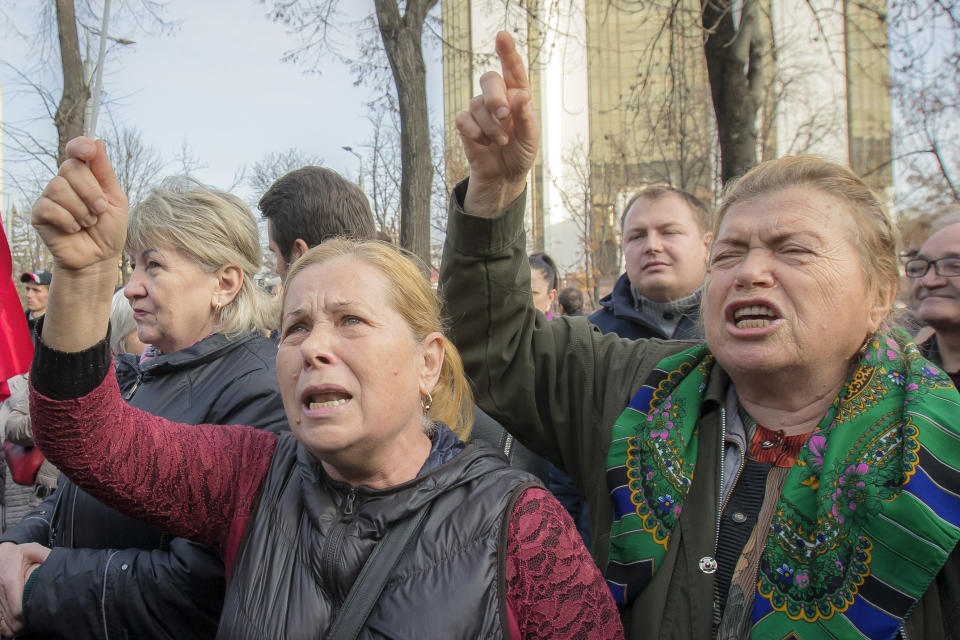 Supporters of the government shout slogans outside Moldova's parliament during a rally in Chisinau, Moldova, Tuesday, Nov. 12, 2019. Prime Minister Maia Sandu's government coalition between a pro-European group and a Russian-backed party has fallen after losing a no-confidence vote in parliament as 63 of 101 lawmakers supported the no-confidence motion.(AP Photo/Roveliu Buga)