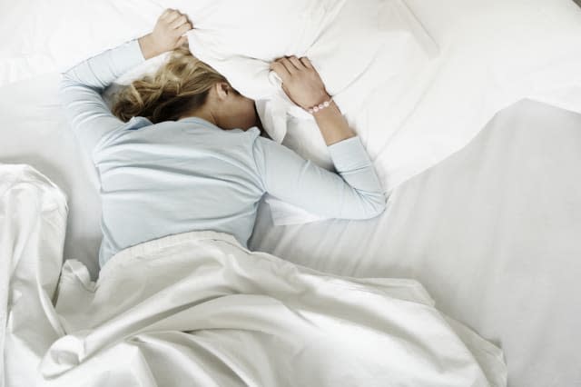 Woman having restless nights sleep