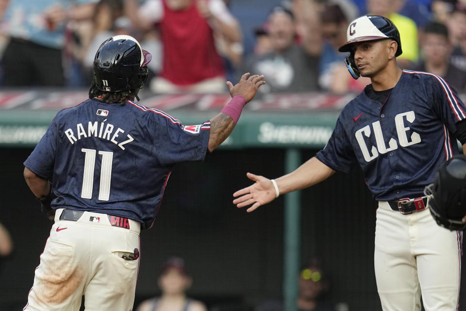 Cleveland Guardians' José Ramírez (11) is congratulated by Andrés Giménez after scoring in the second inning of the team's baseball game against the Toronto Blue Jays, Friday, June 21, 2024, in Cleveland. (AP Photo/Sue Ogrocki)