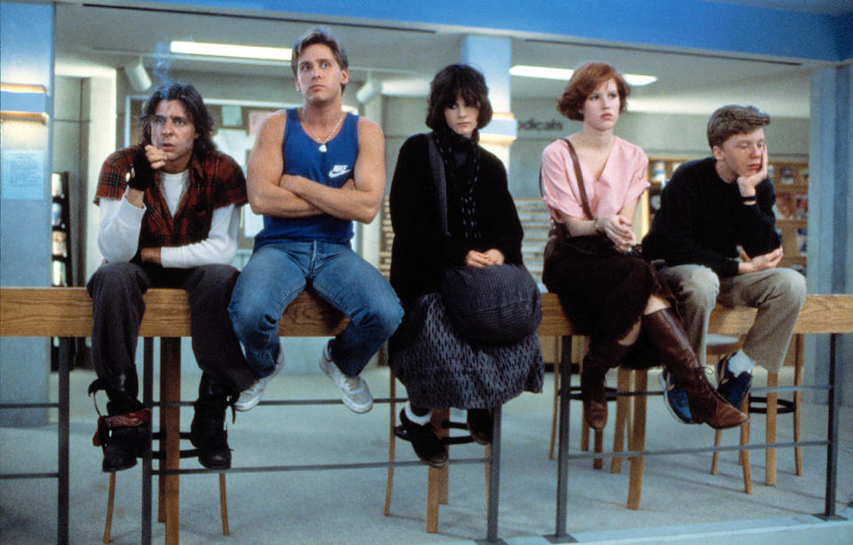 the five main characters sitting on the ledge in the library