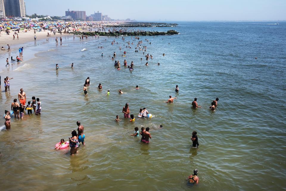 People visit the beach at Coney Island in Brooklyn on July 19, 2020, in New York City. Much of the East Coast is experiencing usually warm weather with highs in the 90s and a heat index that makes it feel over 100 degrees.