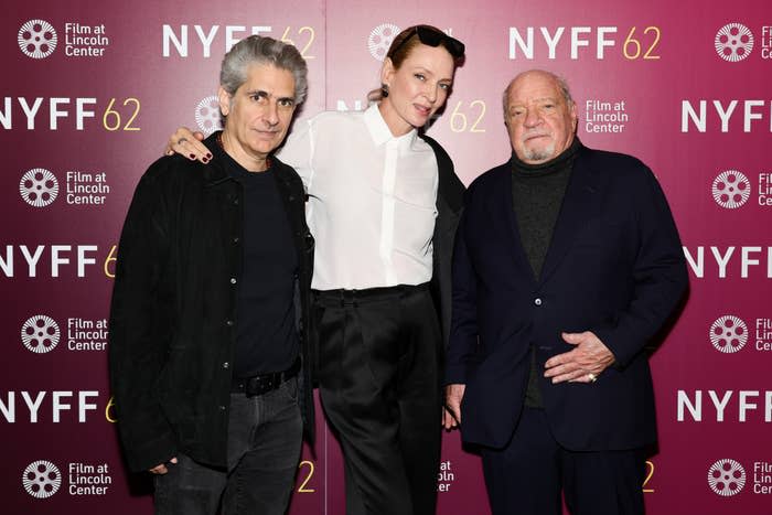 Three people pose on the red carpet at the NYFF event, with one in a black jacket, one in a white blouse, and one in a suit