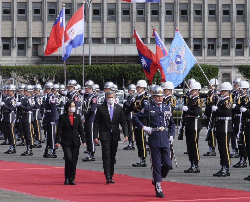 Taiwan's President Tsai Ing-wen, left, and Paraguay's President Mario Abdo Benitez walk past an honor guard at the Presidential House in Taipei, Taiwan, Thursday, Feb. 16, 2023. The outgoing president of Paraguay, whose country is one of Taiwan's few remaining diplomatic allies, spoke of his admiration of the island's democracy Thursday while on a state visit. (AP Photo/Johnson Lai)