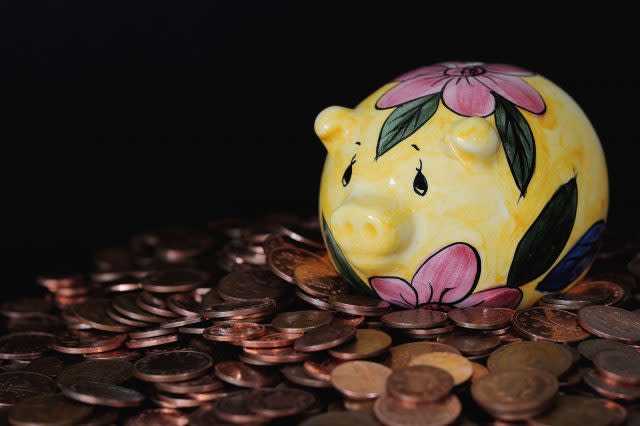 A piggy bank on a pile of coins