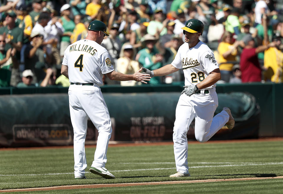 Oakland Athletics' Matt Olson (28) is congratulated by third base coach Matt Williams (4) as he rounds the base after hitting a solo run home run against the Minnesota Twins during the second inning in a baseball game in Oakland, Calif., Sunday, Sept. 23, 2018. (AP Photo/Tony Avelar)
