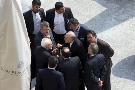 Iran's Foreign Minister Mohammad Javad Zarif (C on left) and head of the Atomic Energy Organization of Iran Ali Akbar Salehi (C on right) talk outside with aides after a morning negotiation session with U.S. Secretary of State John Kerry over Iran's nuclear programme in Lausanne March 19, 2015. REUTERS/Brian Snyder